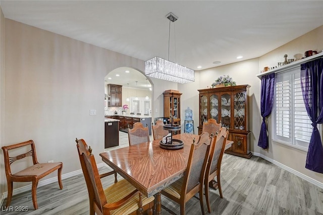 dining area featuring a notable chandelier and light wood-type flooring