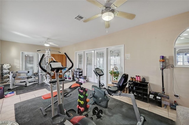 exercise room featuring plenty of natural light, light tile patterned flooring, and ceiling fan