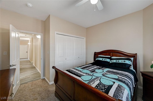 bedroom with ceiling fan, a closet, and light colored carpet