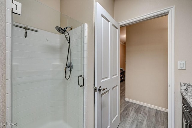 bathroom featuring a shower with door, vanity, and wood-type flooring