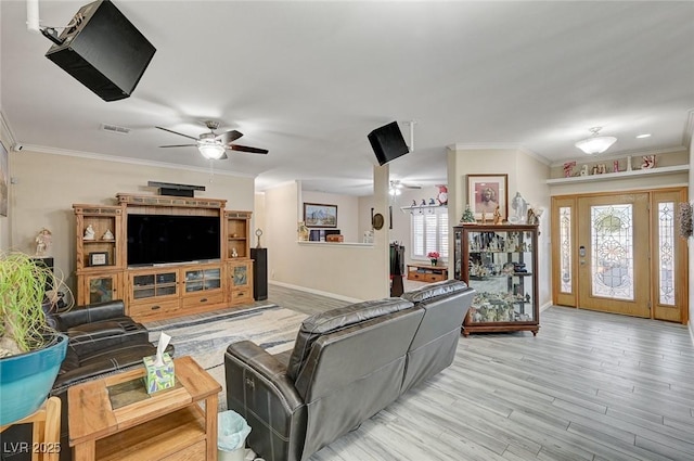 living room featuring plenty of natural light, light hardwood / wood-style floors, ornamental molding, and ceiling fan