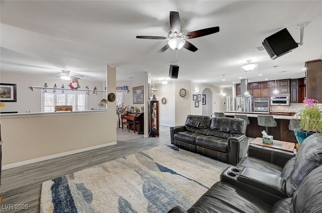 living room with ceiling fan and dark wood-type flooring