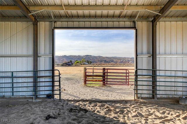 view of horse barn with a mountain view and a rural view