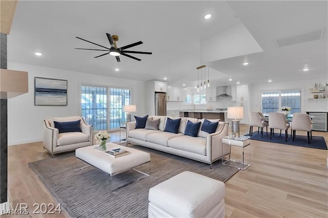 living room with ceiling fan, a healthy amount of sunlight, and light wood-type flooring