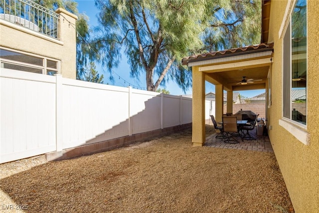 view of yard with ceiling fan and a patio area