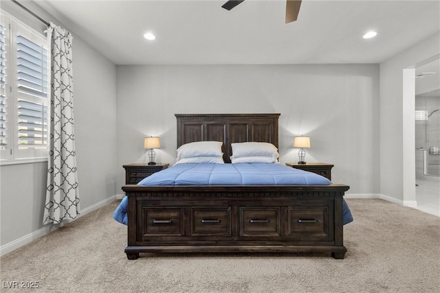 carpeted bedroom with ceiling fan, connected bathroom, and multiple windows