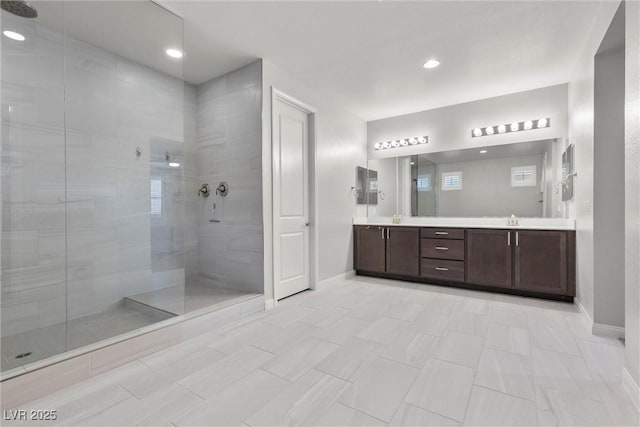 bathroom featuring tile patterned flooring, vanity, and tiled shower