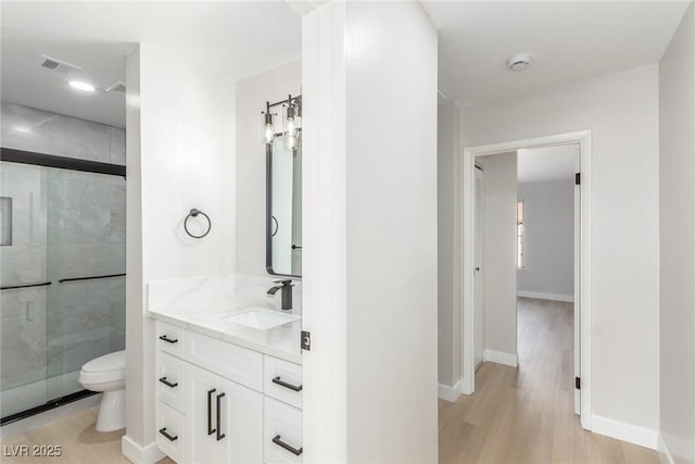 bathroom featuring hardwood / wood-style floors, vanity, toilet, and walk in shower