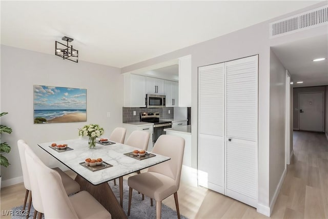 dining room featuring a notable chandelier and light hardwood / wood-style floors