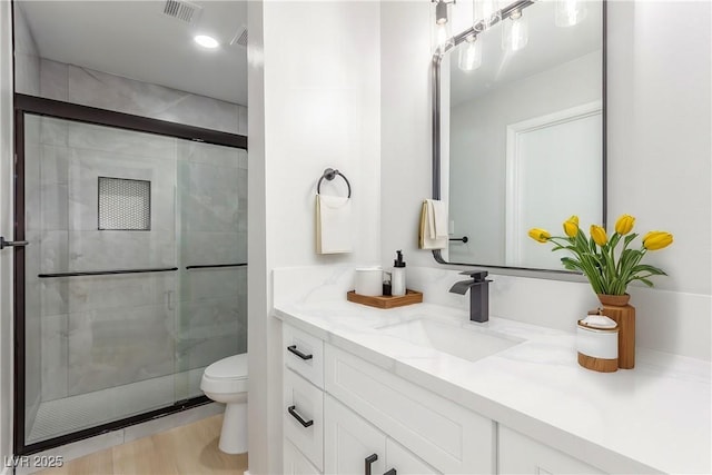 bathroom with vanity, toilet, and walk in shower