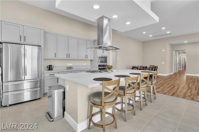 10301 Fairview Ridge Ct, Las Vegas, NV 89166 - kitchen with freestanding refrigerator, a kitchen island, range hood, light countertops, and light tile patterned floors