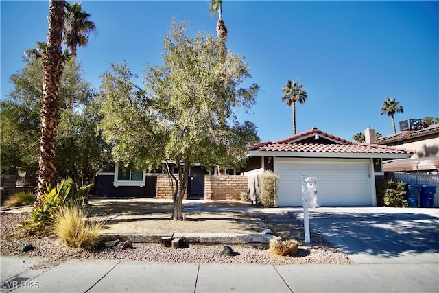 view of front of home with central AC unit and a garage