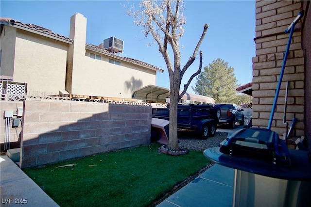 view of yard with central AC and a carport