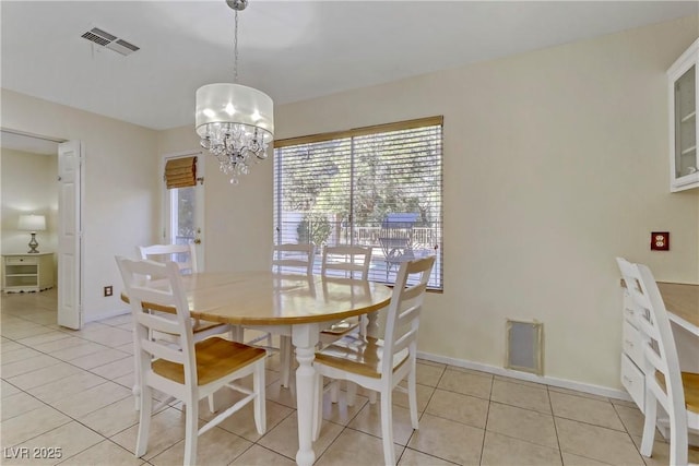 dining area with light tile patterned flooring and an inviting chandelier