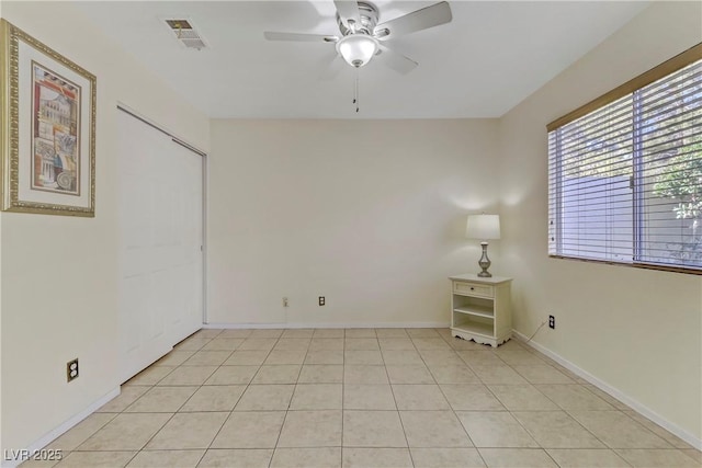 empty room with light tile patterned floors and ceiling fan