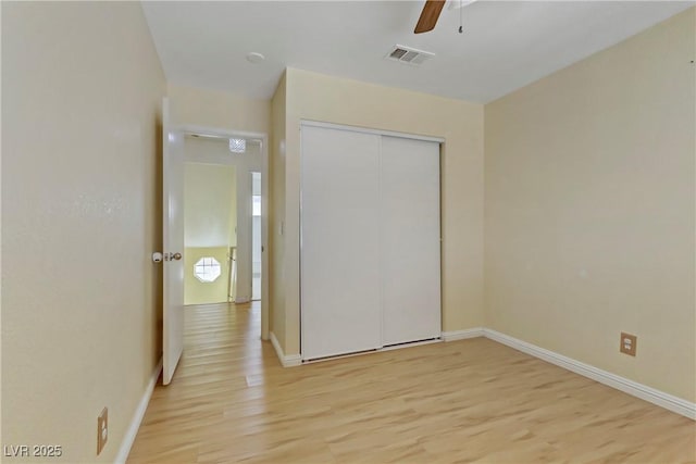 unfurnished bedroom with a closet, light hardwood / wood-style flooring, and ceiling fan