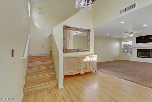 stairs with hardwood / wood-style flooring and ceiling fan