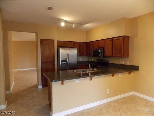 kitchen featuring a kitchen bar, kitchen peninsula, sink, and appliances with stainless steel finishes