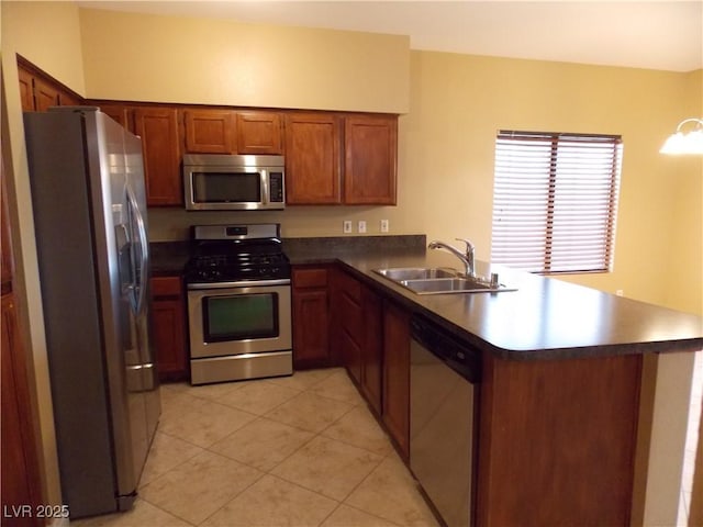 kitchen with kitchen peninsula, appliances with stainless steel finishes, light tile patterned floors, and sink