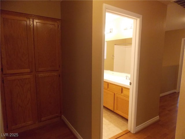 hall featuring light wood-type flooring and sink