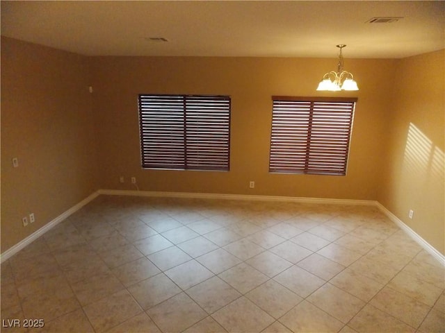 empty room featuring light tile patterned floors and a notable chandelier