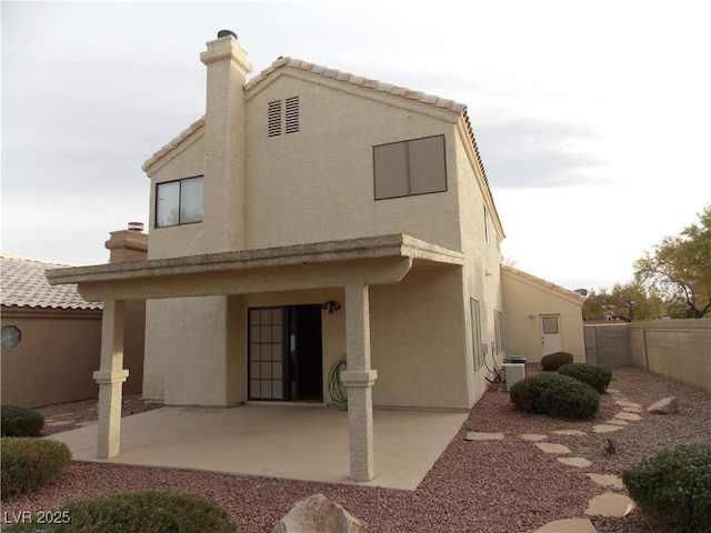 rear view of house featuring central AC unit and a patio