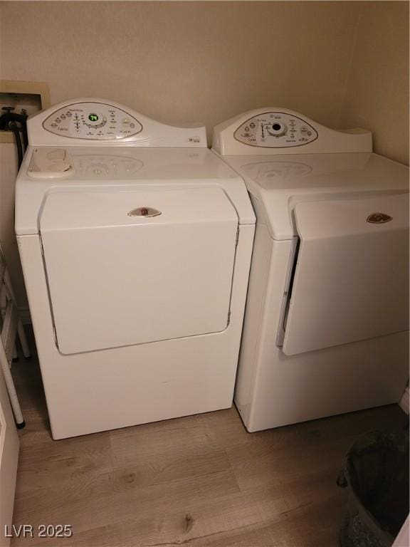 laundry room featuring independent washer and dryer and light wood-type flooring