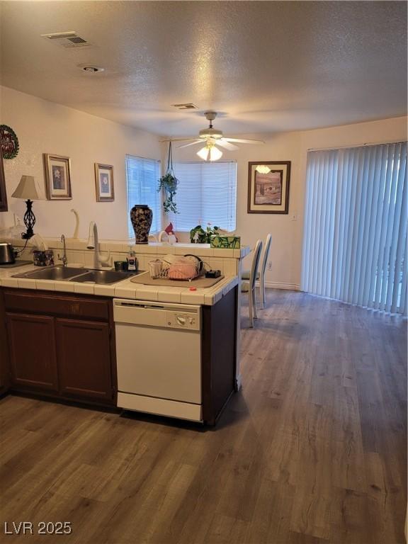 kitchen with sink, a textured ceiling, dark hardwood / wood-style floors, dishwasher, and ceiling fan