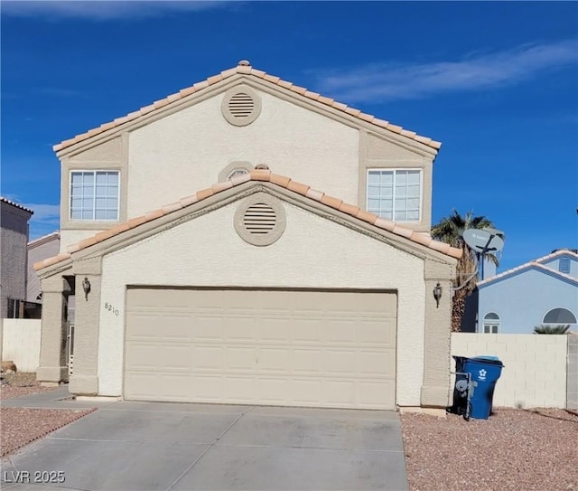 view of front of home with stucco siding, fence, concrete driveway, and a tile roof