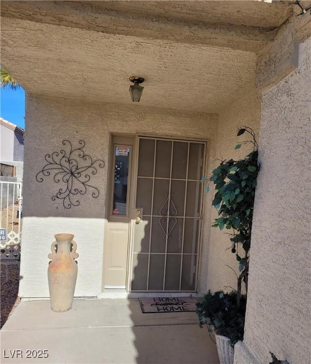 doorway to property featuring stucco siding