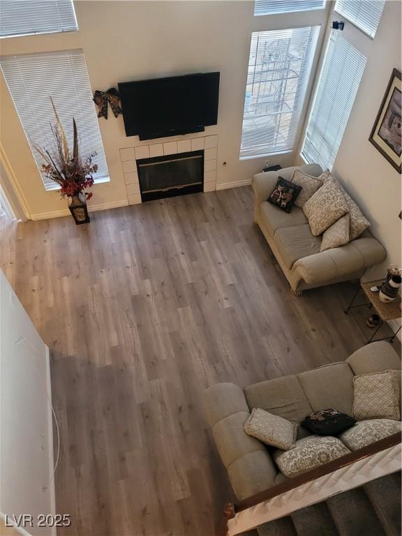 living room with wood-type flooring and a tile fireplace