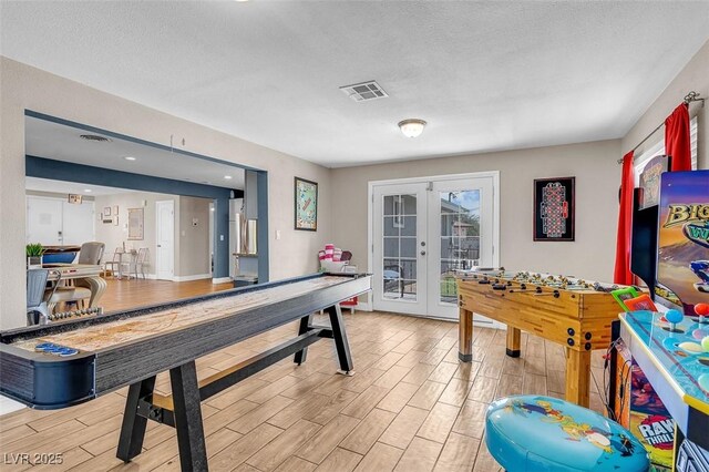 playroom featuring french doors and a textured ceiling