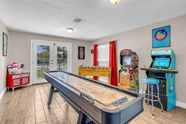 recreation room featuring a textured ceiling and french doors