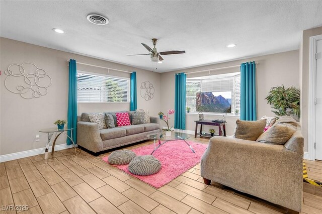 living room with ceiling fan and a textured ceiling