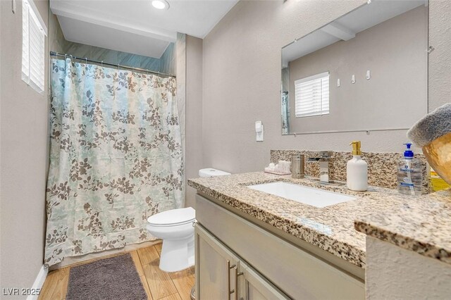 bathroom featuring wood-type flooring, vanity, and toilet