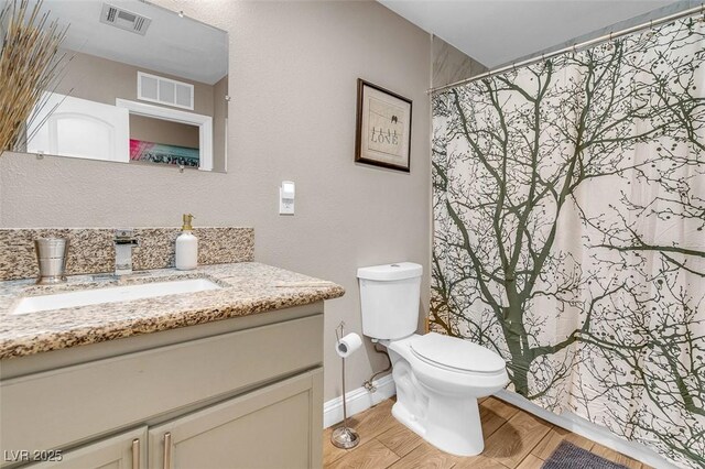 bathroom with vanity, toilet, and wood-type flooring