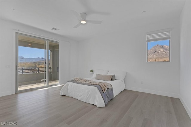 bedroom with ceiling fan, access to exterior, a mountain view, and light wood-type flooring