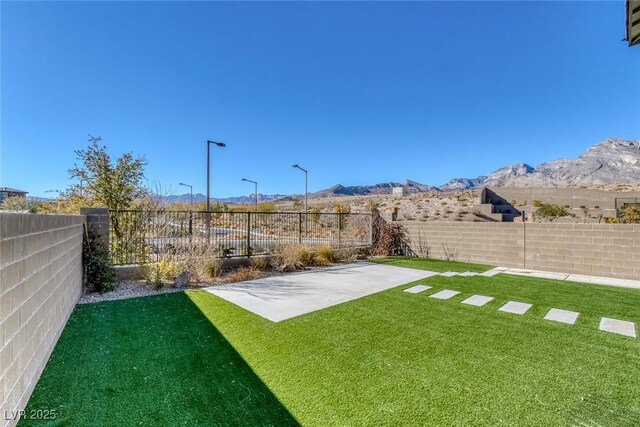 view of yard with a mountain view and a patio