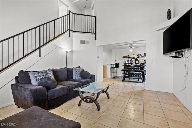 tiled living room with a towering ceiling and ceiling fan