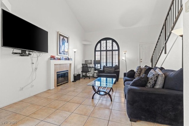 tiled living room with a tile fireplace and lofted ceiling