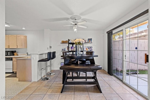 tiled dining room featuring ceiling fan and sink