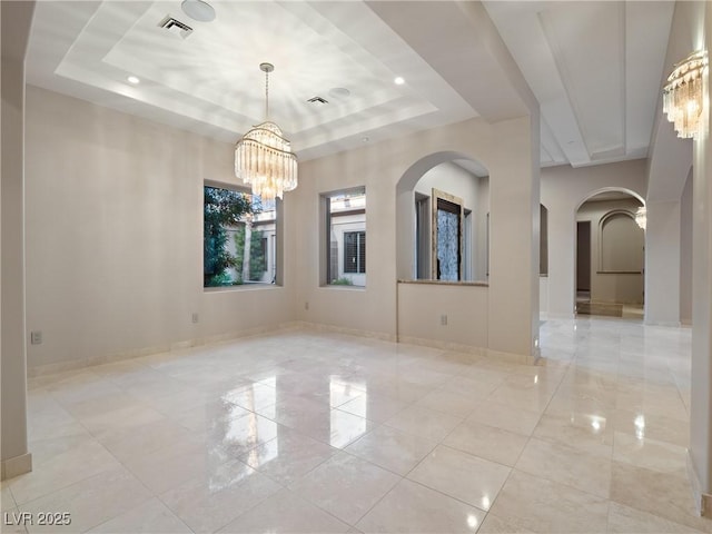 unfurnished room with a raised ceiling and a notable chandelier