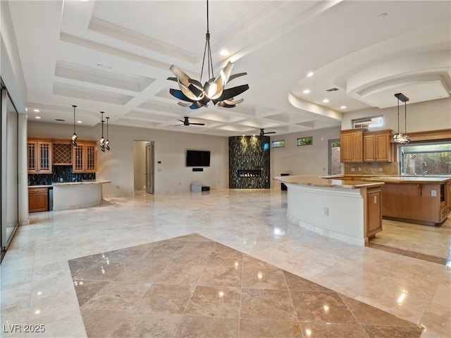 kitchen with pendant lighting, a large island, ceiling fan, and coffered ceiling