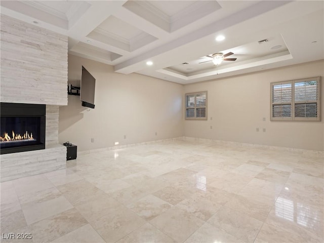 unfurnished living room featuring ceiling fan, a large fireplace, ornamental molding, and coffered ceiling