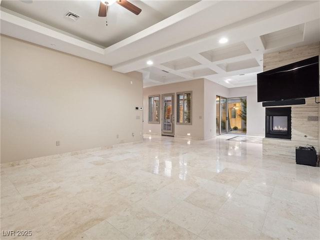 unfurnished living room with a multi sided fireplace, beam ceiling, ceiling fan, and coffered ceiling