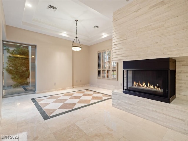 unfurnished living room featuring a fireplace and a tray ceiling