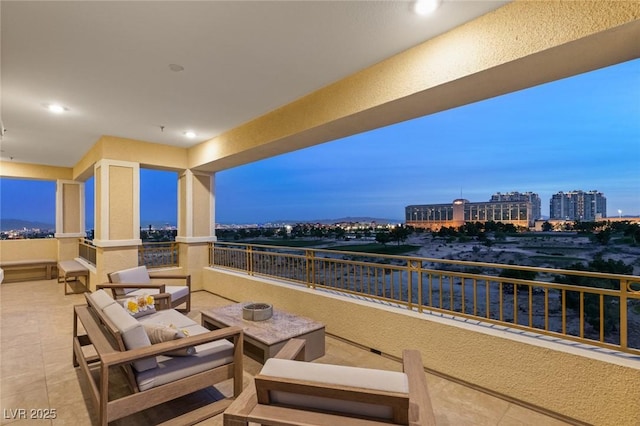 patio terrace at dusk with an outdoor living space and a balcony