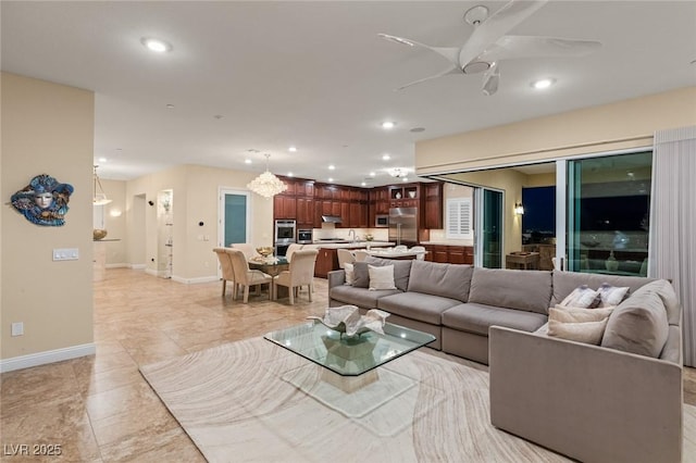 living room with ceiling fan, light tile patterned flooring, and sink