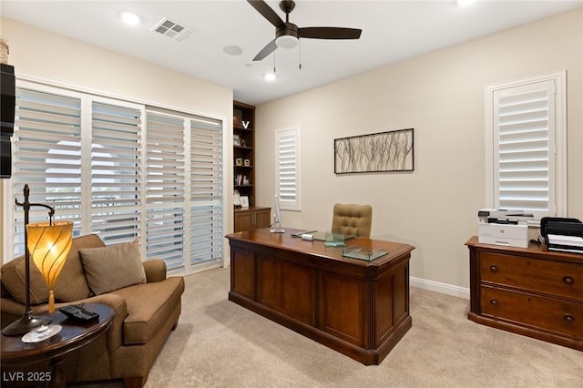 carpeted office with ceiling fan and built in features