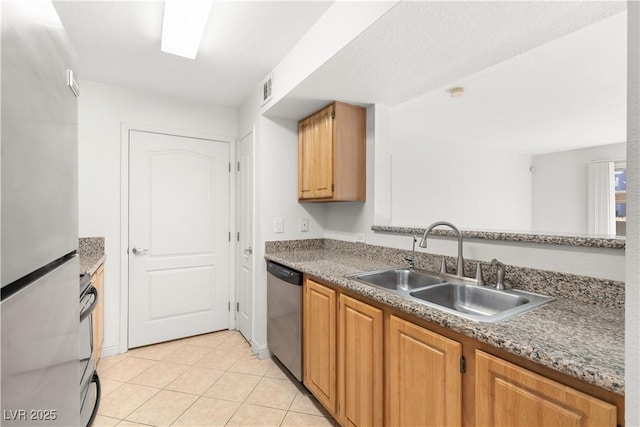 kitchen with refrigerator, sink, stainless steel dishwasher, light tile patterned flooring, and range